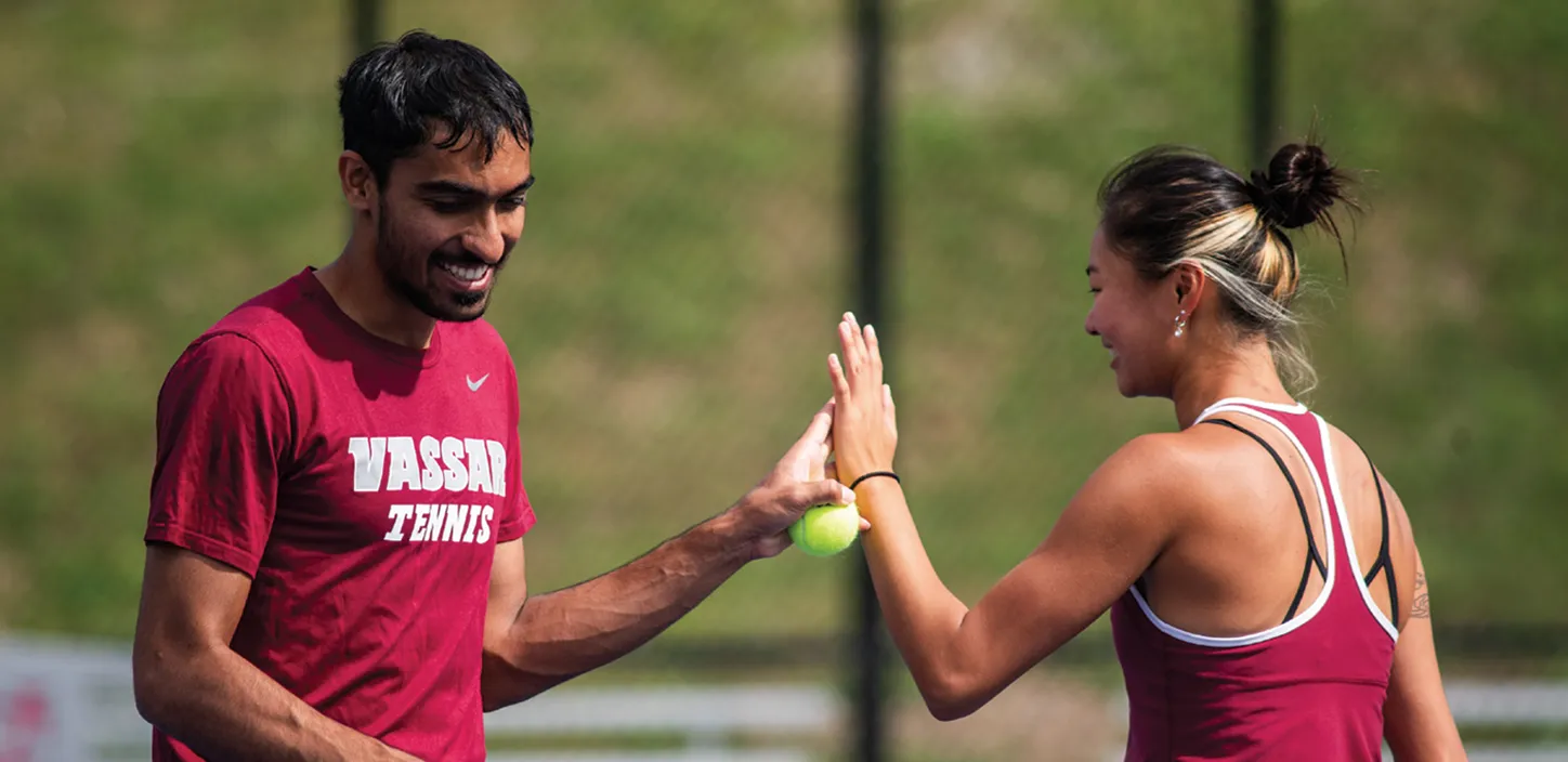 Male and female tennis players high fiving during open play