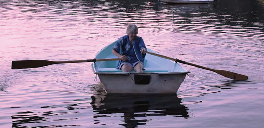Jan Farrington paddles a boat across the lake adjacent to the camp.