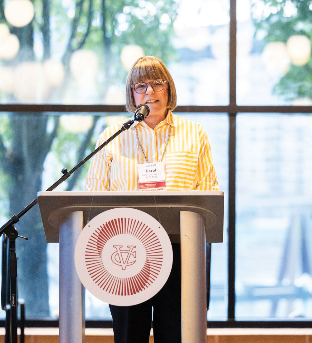 Carol Ostrow ’77 at a podium co-hosting the event.