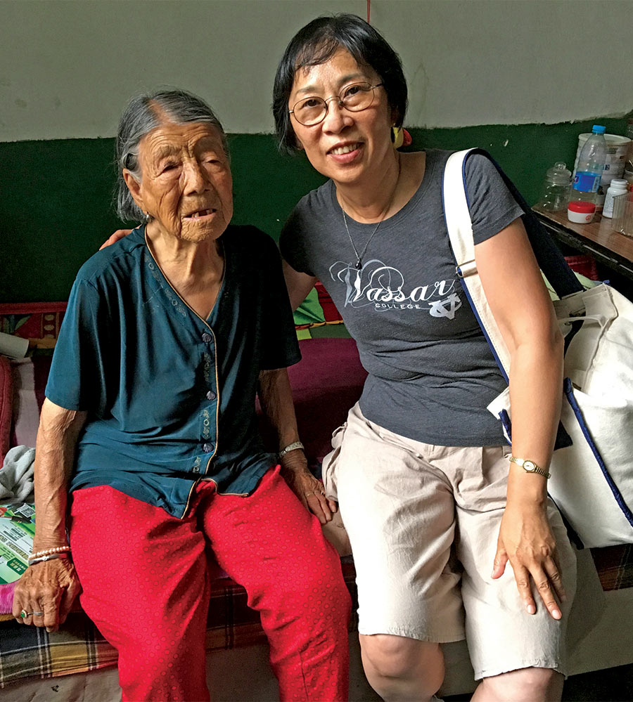 Professor Qiu sits next to survivor Hao Yuelian during a visit to China.