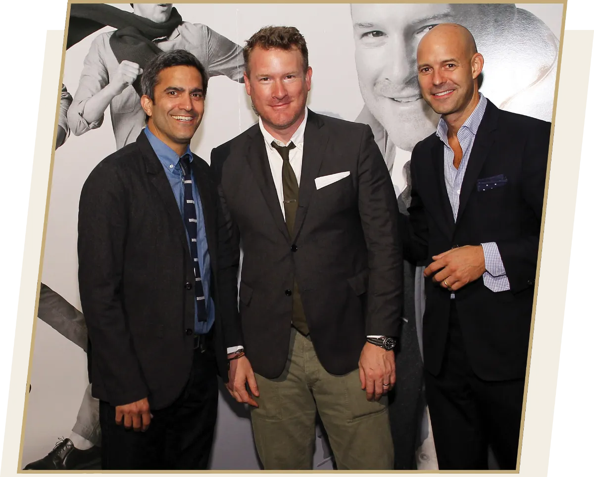 Mark Breitbard (’90), President and CEO of Global Gap Brands,  stands next to Todd Snyder and Chris Mitchell, all in suits.