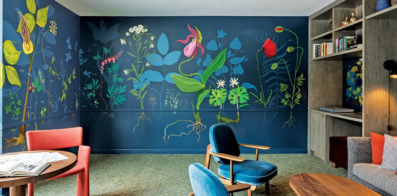 A colorful floral mural on the wall in a lounge at the Heartwood hotel.