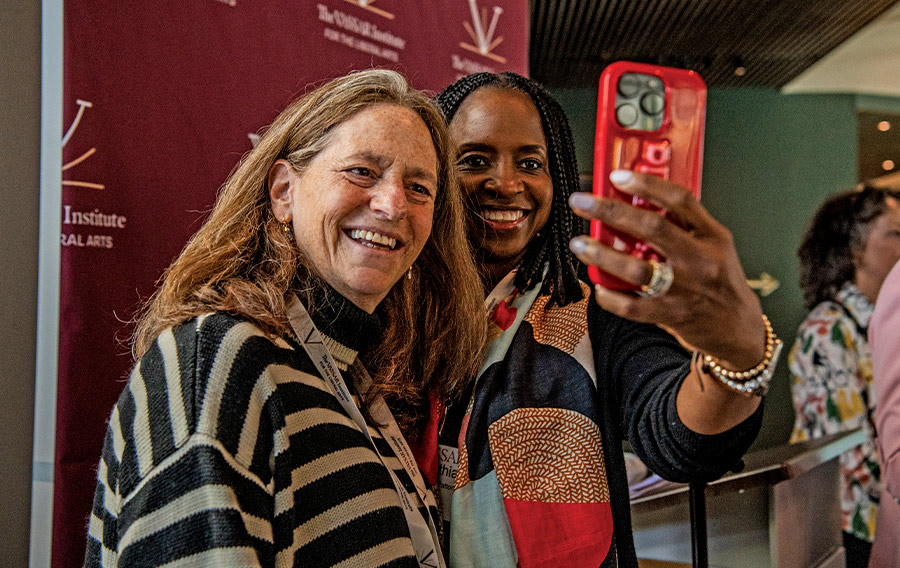 Two women smile while taking a selfie.