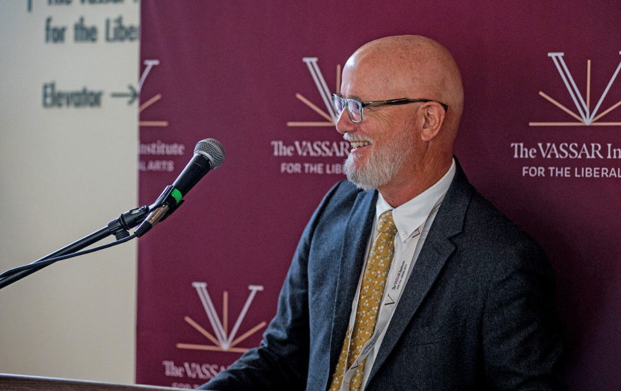 Professor Brigham speaks at a podium during the institute ribbon-cutting ceremony.