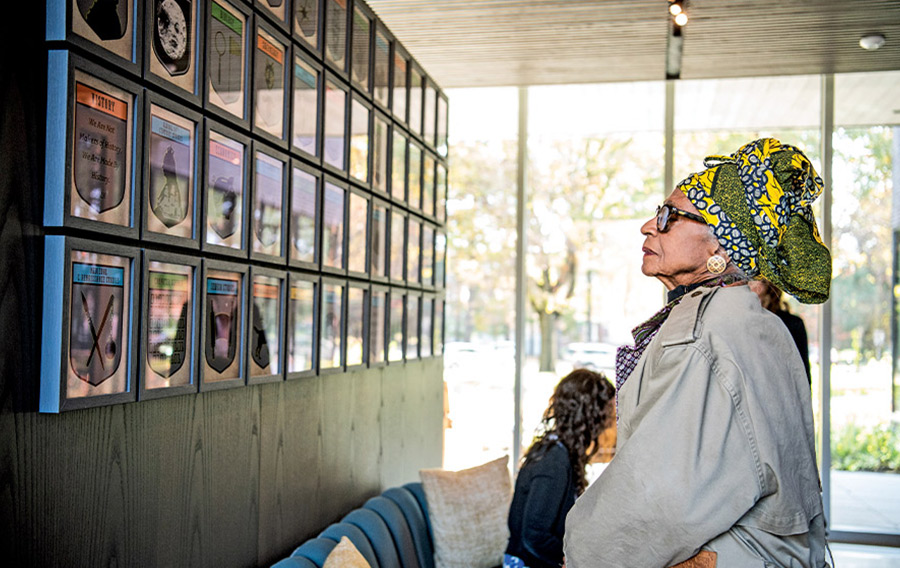 A woman in African headdress views an art installation at the Heartwood