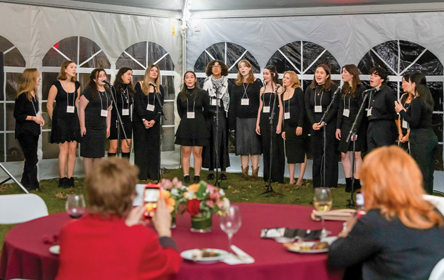 Several  women dressed in black attire—The Night Owls—entertain with a capella music.