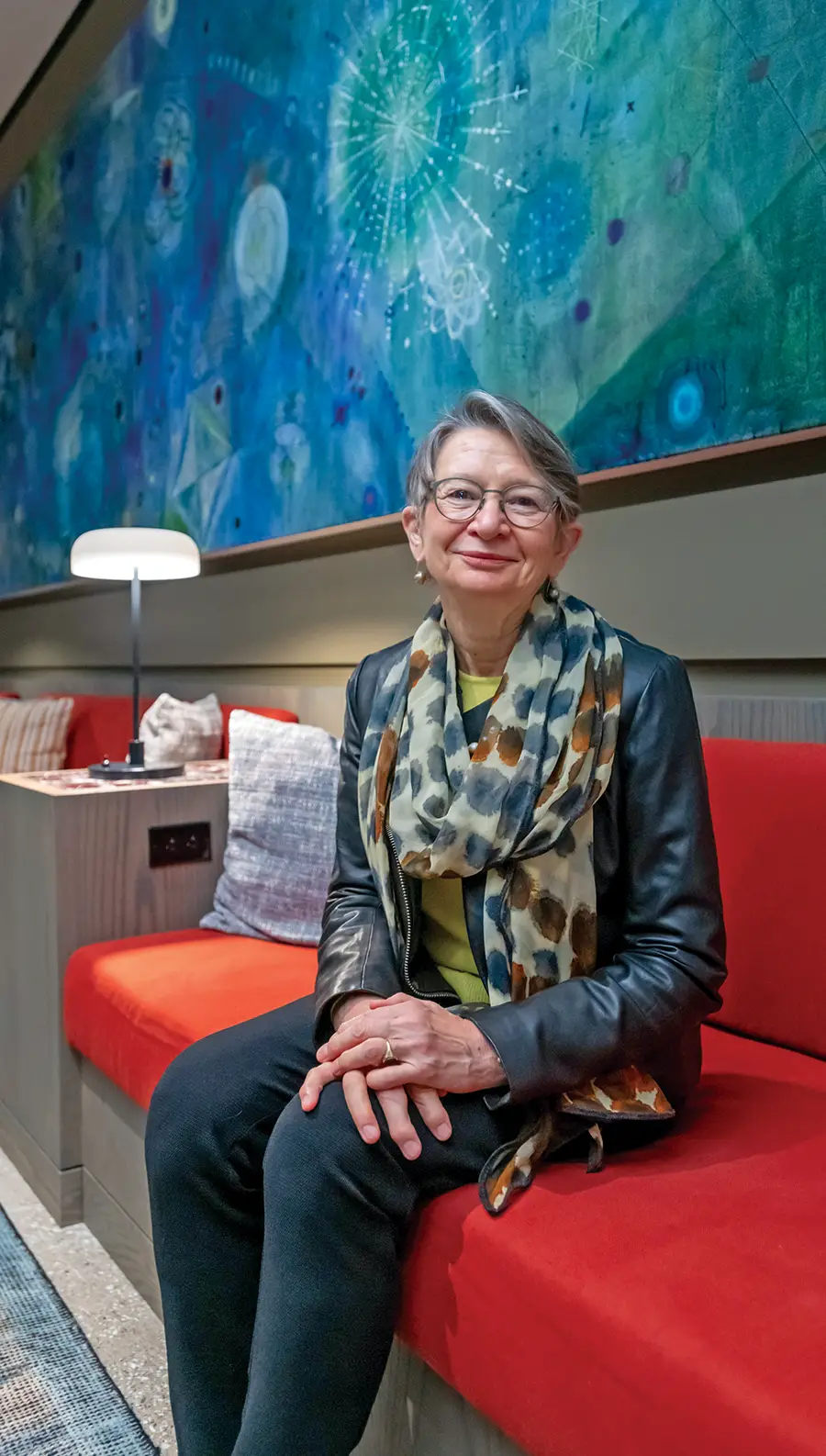 Andrea Baldeck (’72) seated in a colorful lounge named after her in The Heartwood.