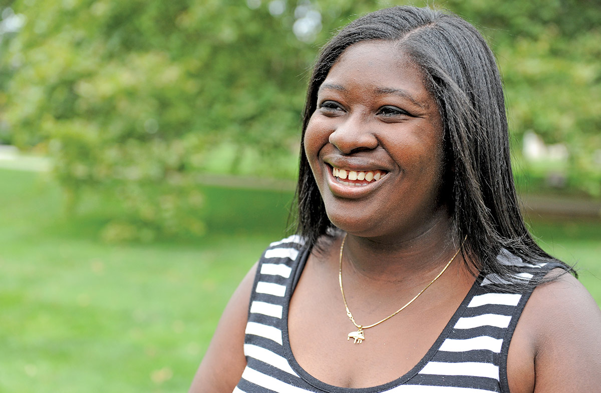 Naja Jackson (’18), a teacher in Poughkeepsie, in front of some greenery.