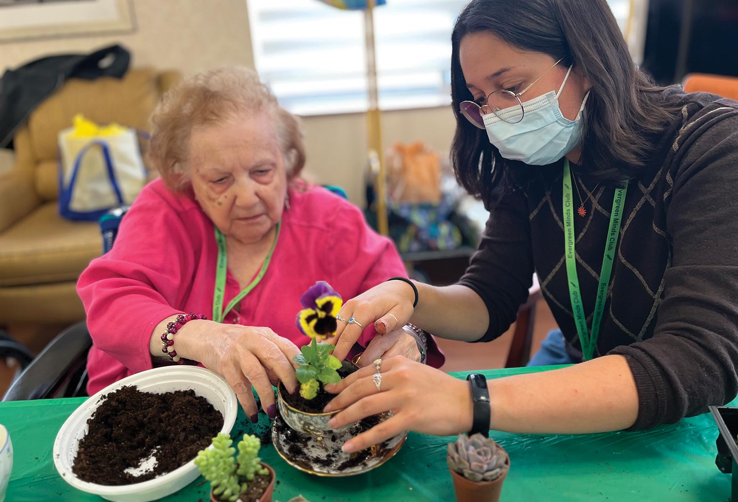 Student Sasha Zweig helping a dementia patient plant herbs and succulents.