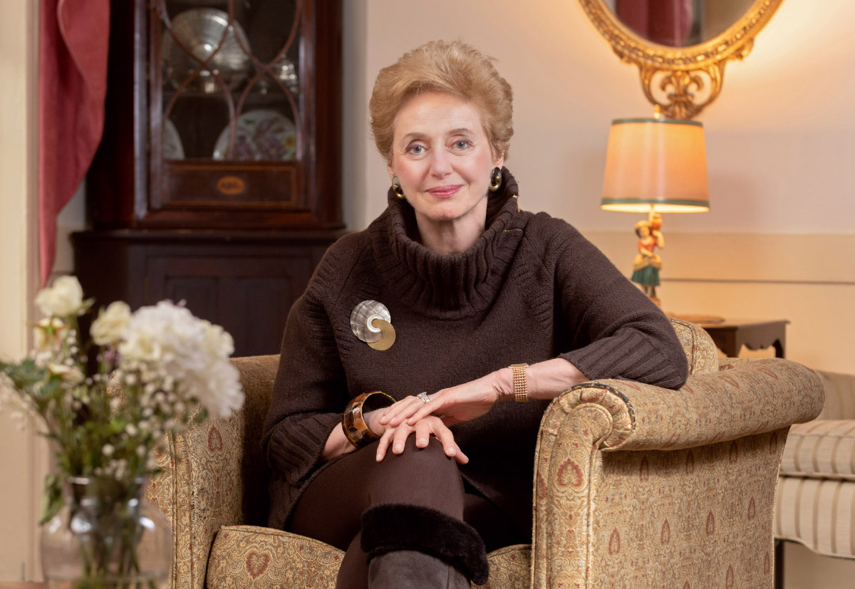 Dr. Georgette F. Bennett wearing brown sweater while sitting in tan patterned chair
