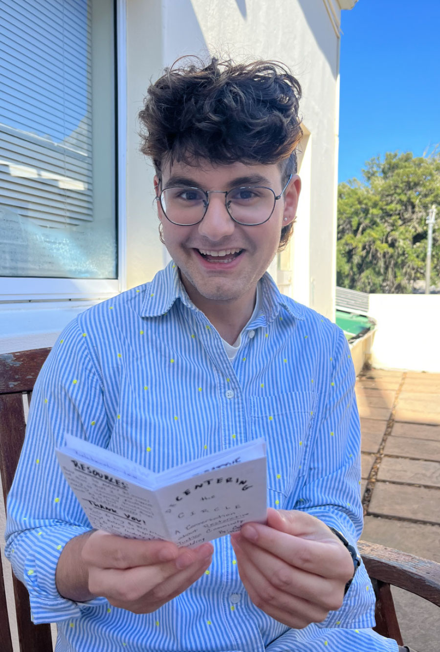 Calder Beasley ’25 smiles holding a zine that he created.