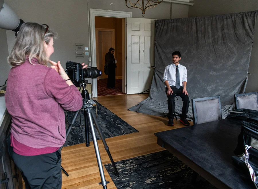 Photographer takes professional headshots of Vassar students in front of gray background during Sophomore Career Connections.