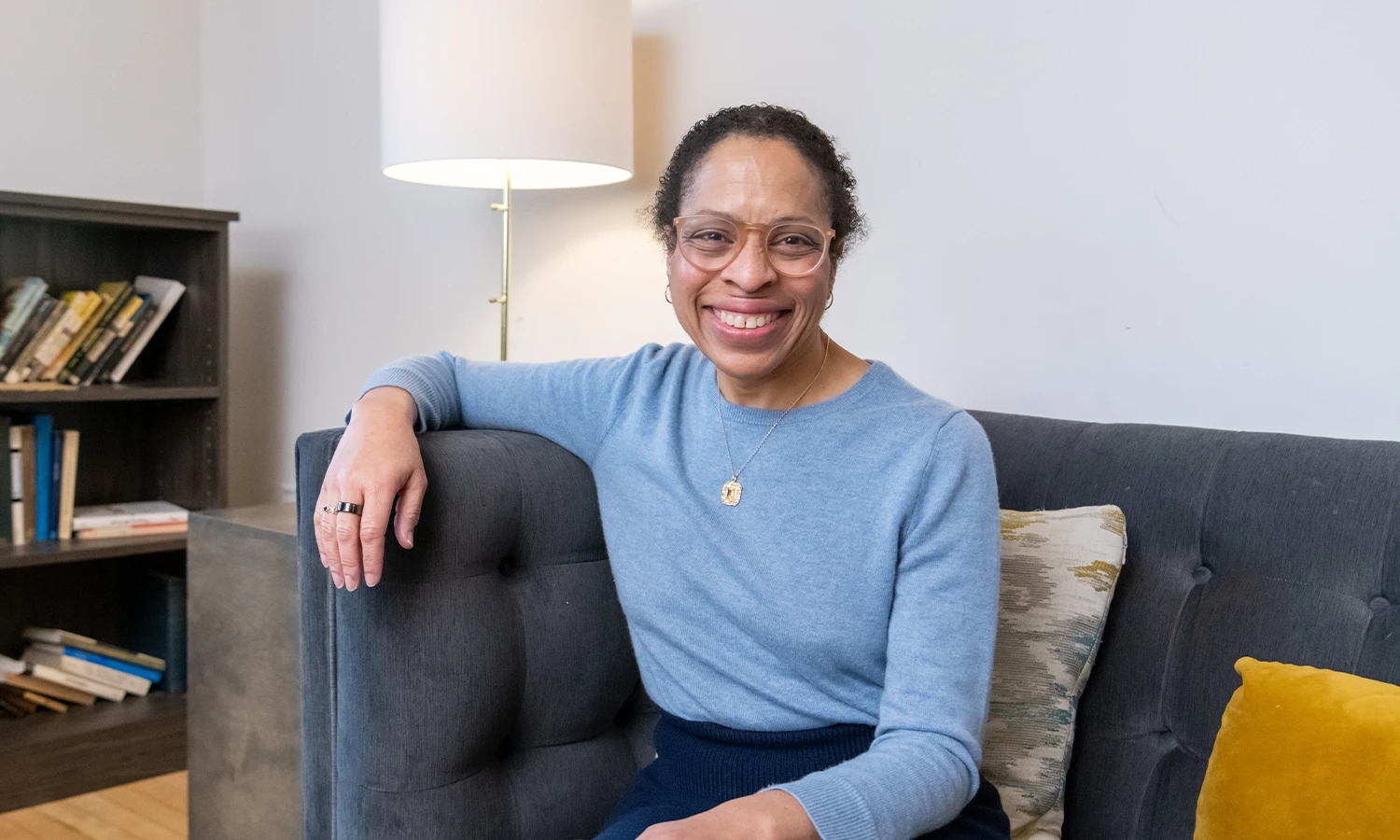 Portrait of Alexia Gordon ’91 on a gray couch.