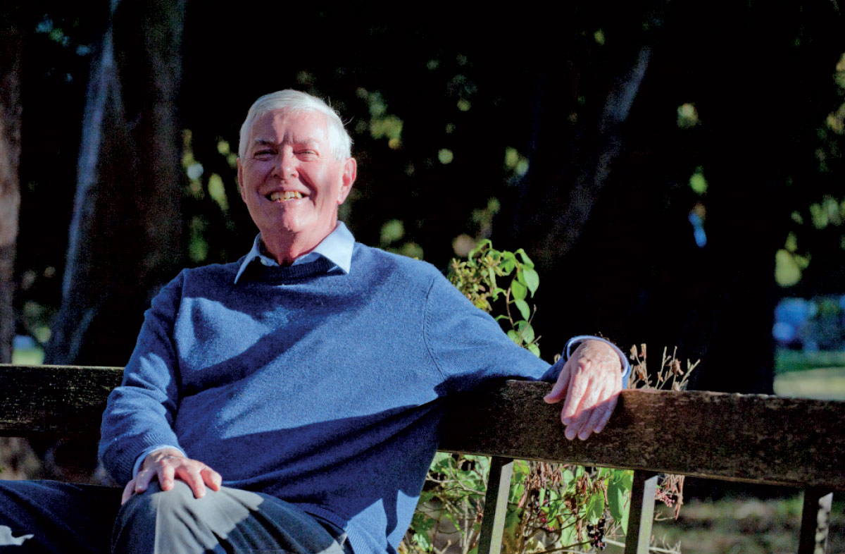 Michael McCarthy sitting on an outdoor bench and smiling.