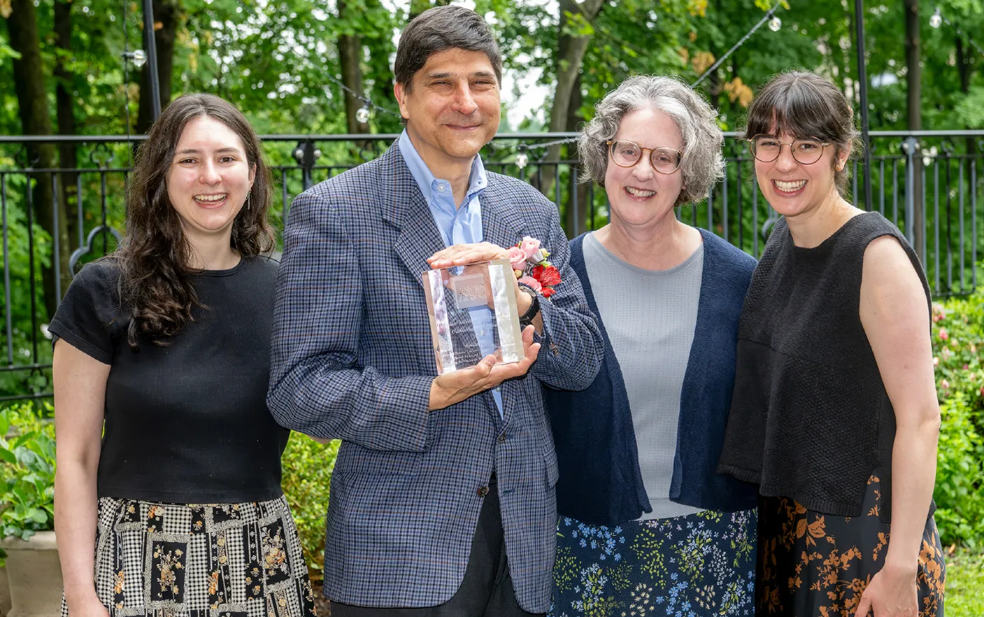Portrait of Ronald D. Patkus holding the Outstanding Faculty/Staff Award with his wife and two daughters.