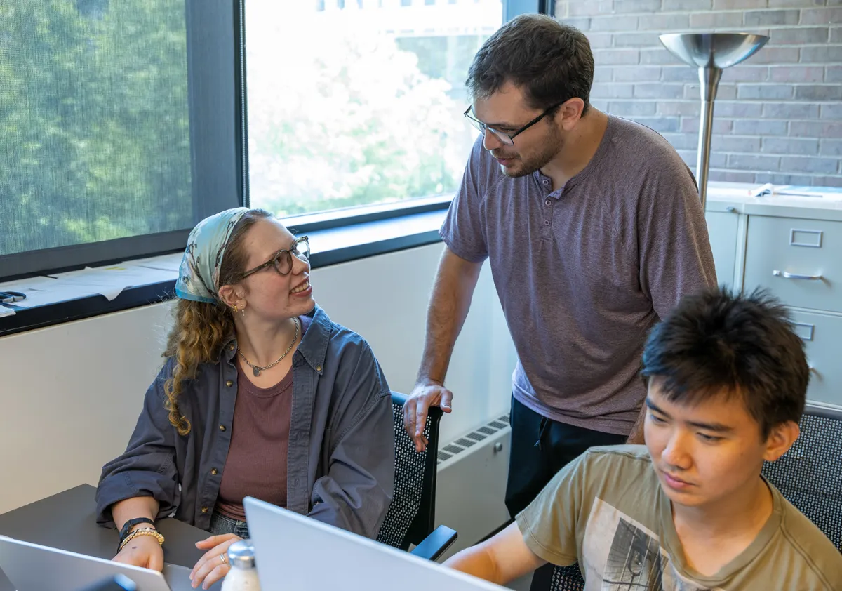 Professor Josh de Leeuw assists two students in a computer lab.</p>
<p>