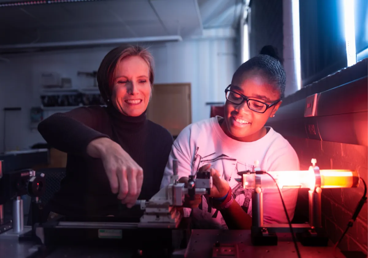 Professor Jenny Magnes and a student view a light array.