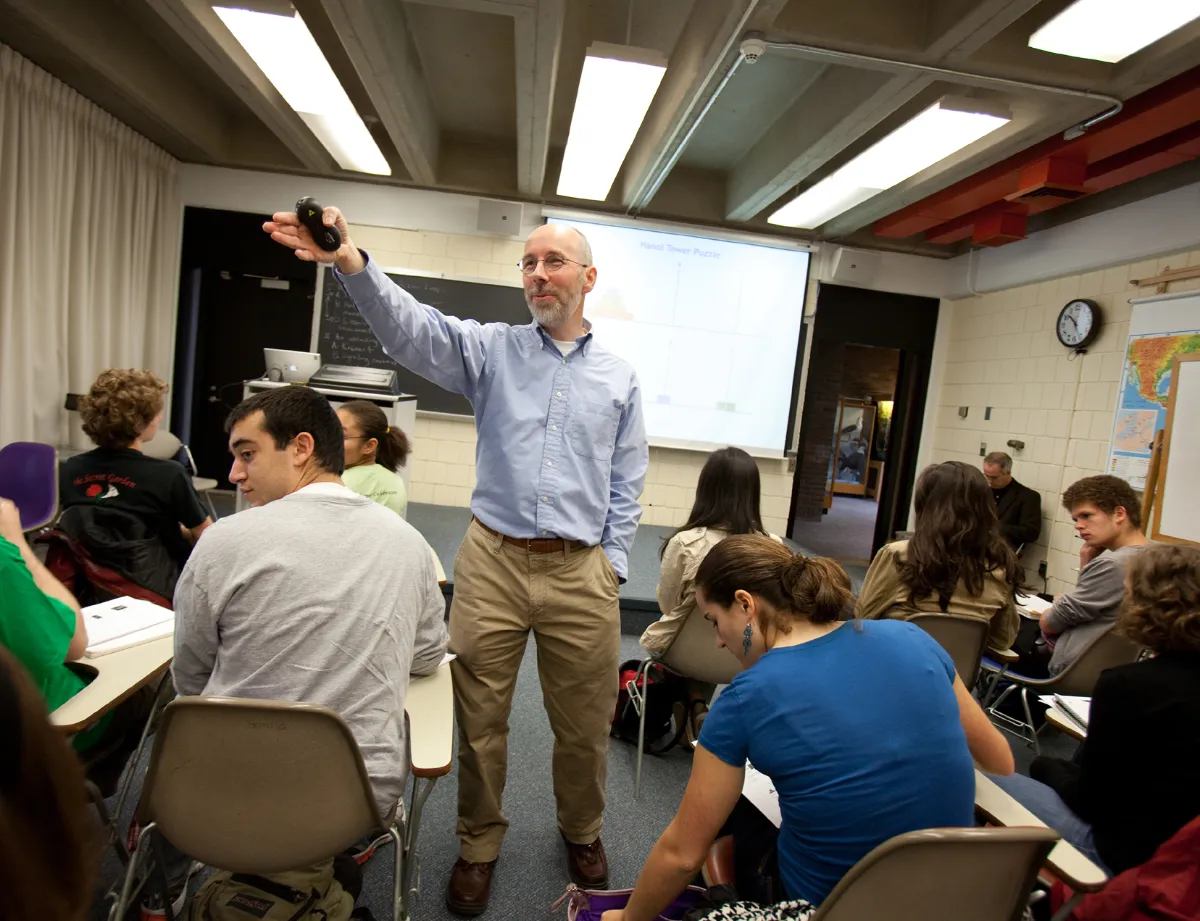 Professor John Long gesticulates during a classroom full of students.