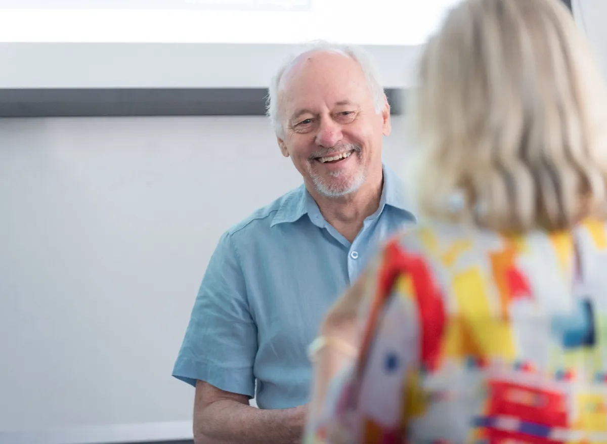 Professor Ken Livingston smiles while talking to a student..