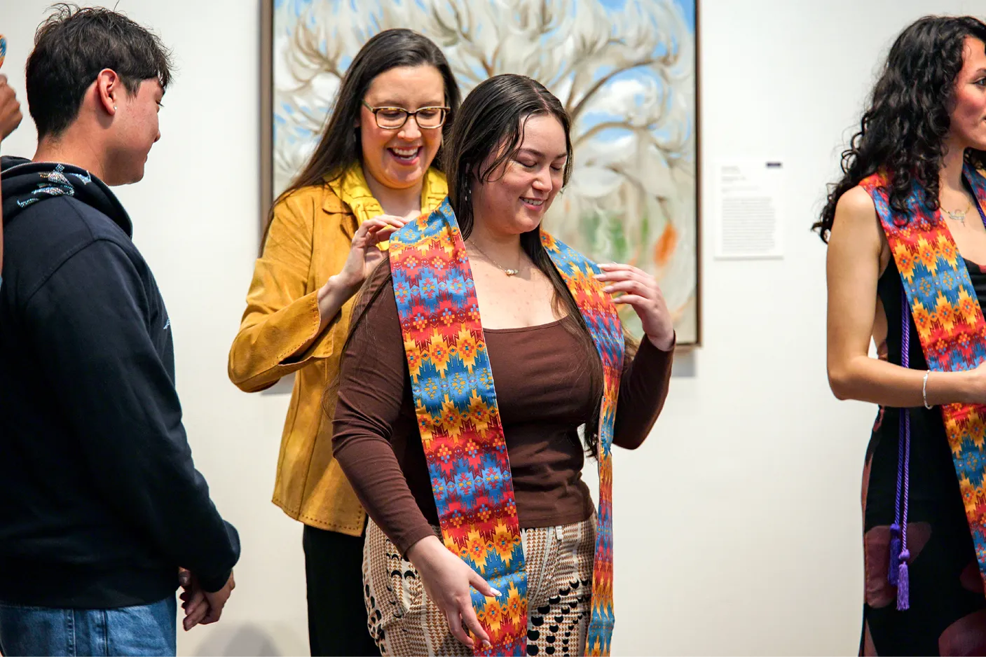 A student receives a feather-tipped stole, commemorating her Native American and/or Indigenous identity.