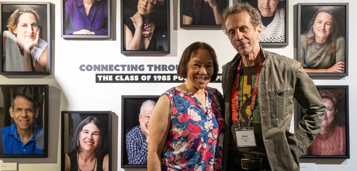 Nancy Kwang Johnson ‘85 and Daniel Reichert ‘85 stand at the Palmer Gallery, a portrait exhibition in the background.