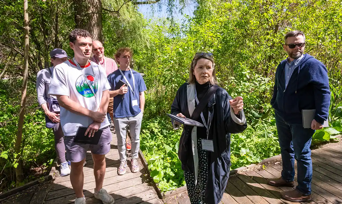 Karen Van Lengen ‘73 leads a group of students on a tour of a lush part of campus. 
