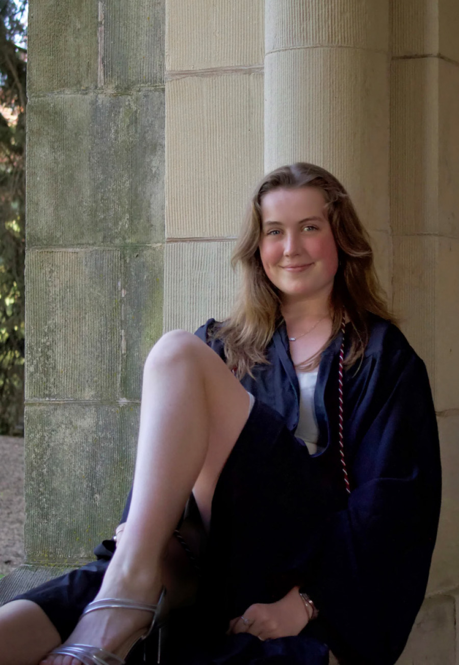 Molly Ardren ’25 dressed for graduation, sitting on the steps of the Chapel.