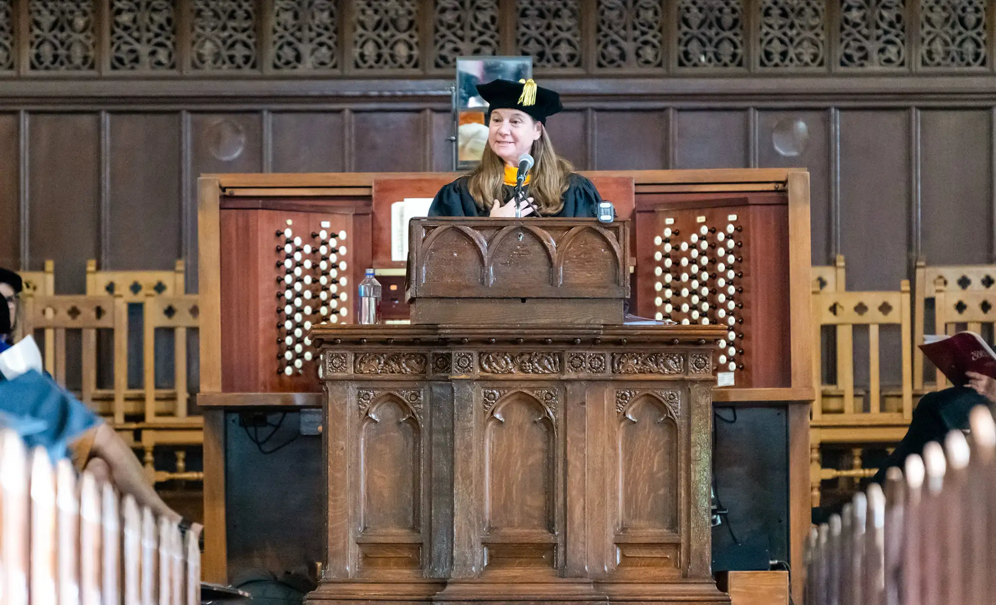 Professor Jodi Schwarz standing at the front of the Chapel, speaking for the 161st Convocation.
