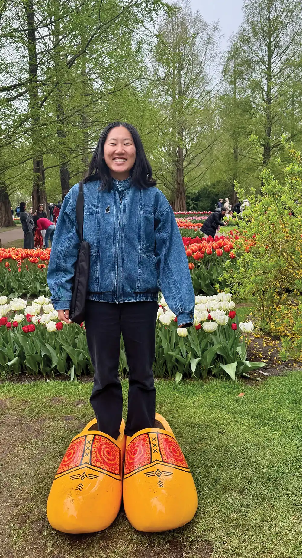 Anabel Lee ’26 in Amsterdam, standing in giant, painted wooden shoes that are part of an art installation.