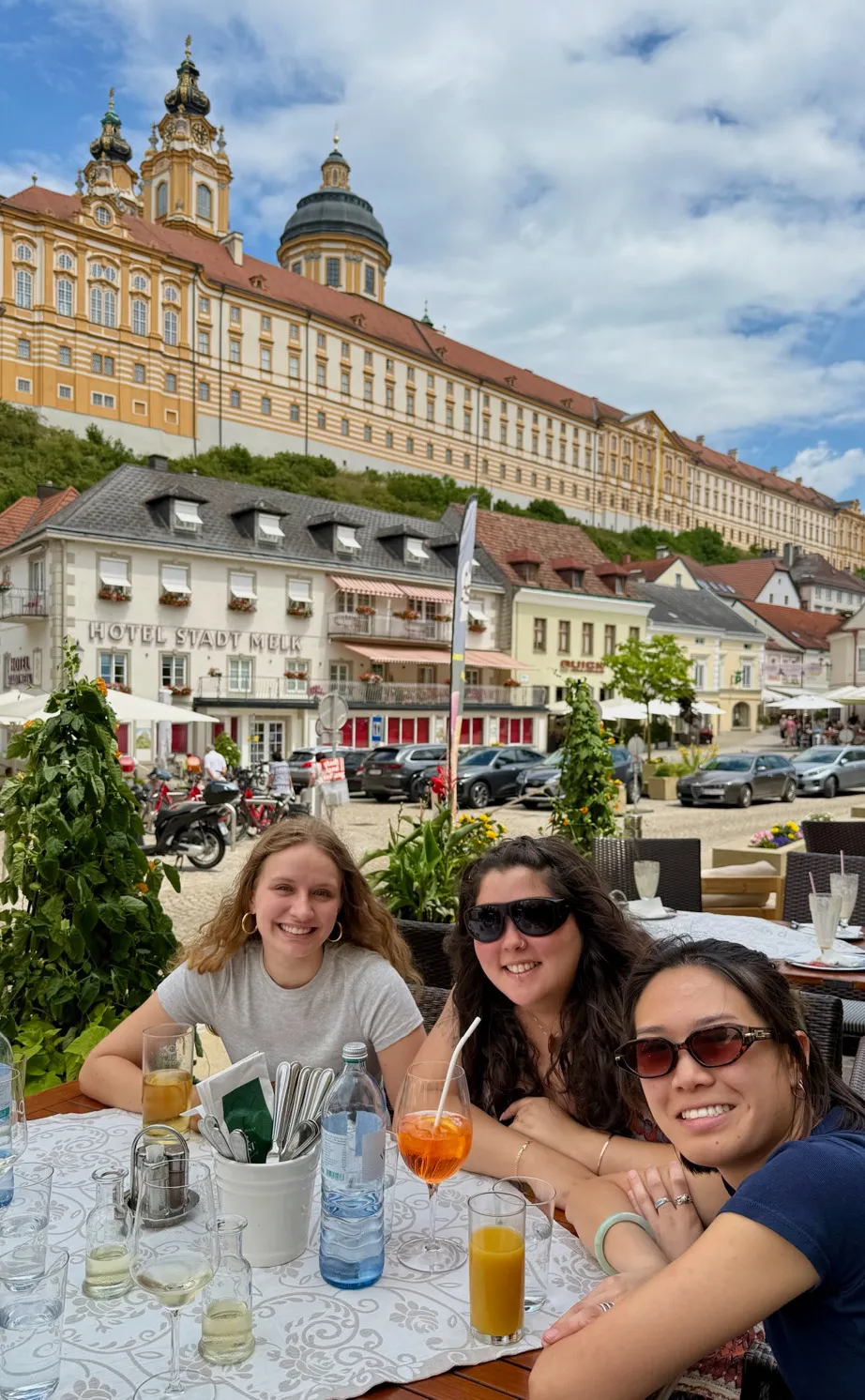 Kathleen Chang, Betsy Subiros, and Emma Larson—all ‘25—sitting outside, enjoying a meal at a local restaurant in Europe.