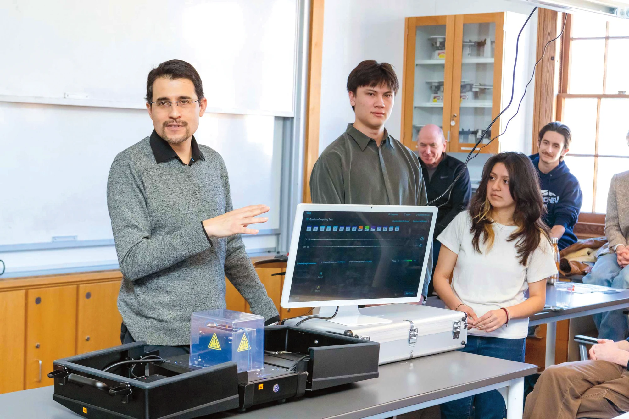 A man is showing a computer to a group of people.