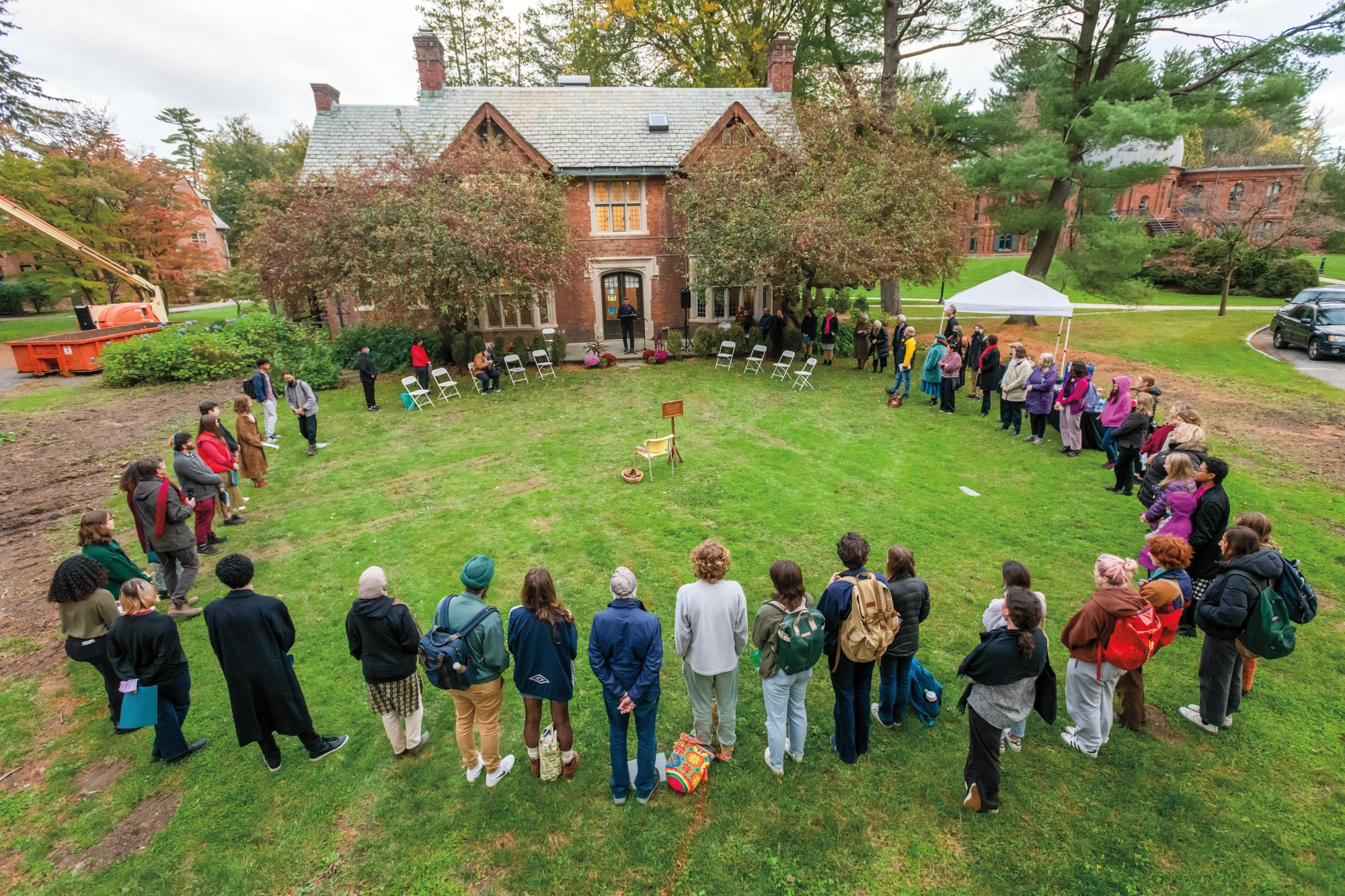 Students form a large circle on the lawn outside a Vassar campus building.